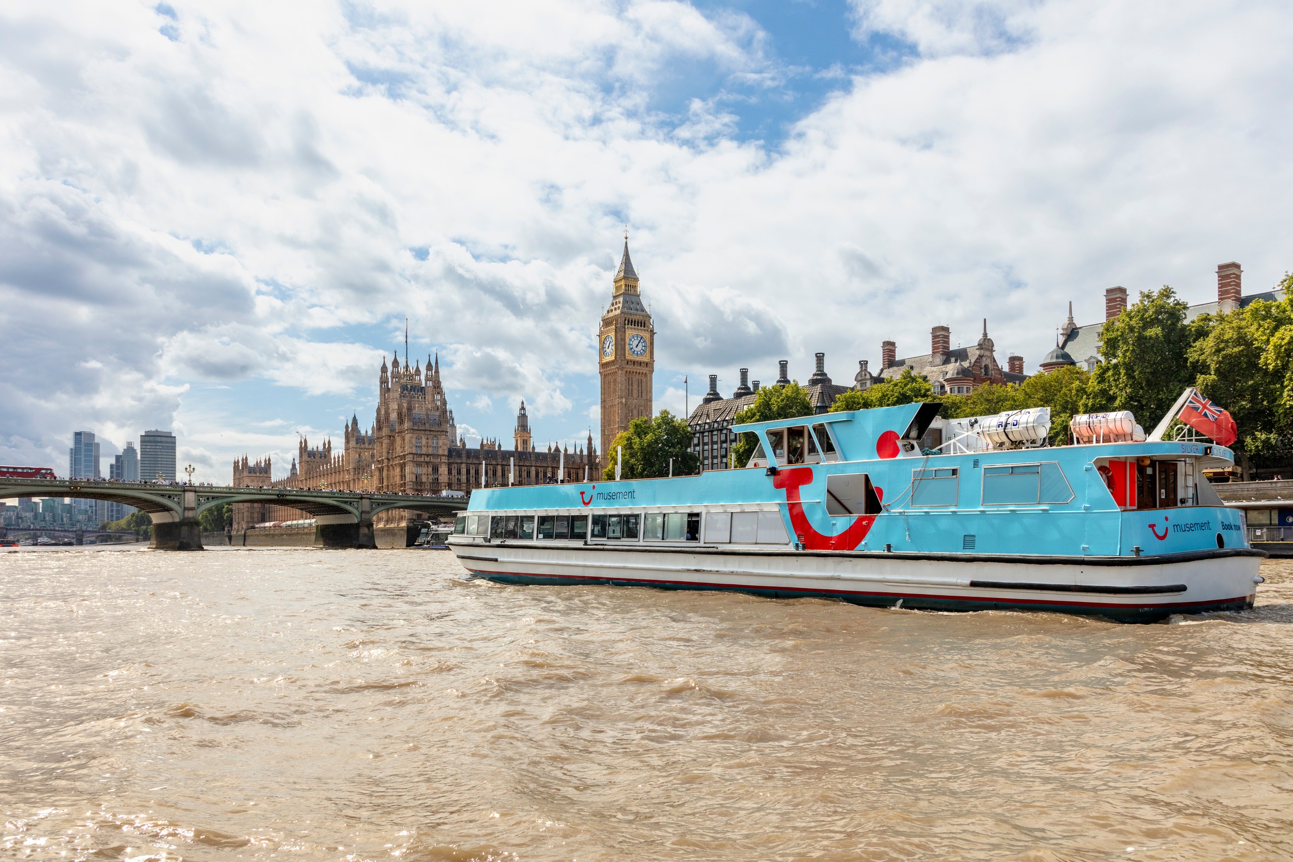 Riverboat on Thames with London skyline and Big Ben visible.