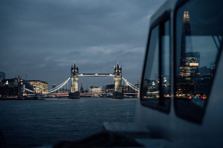View of London Bridge and cityscape at dusk with cloudy sky.