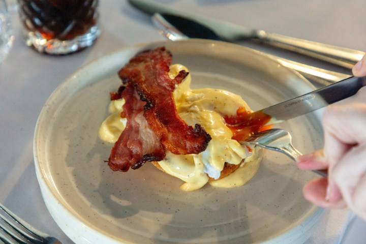 Bacon and sauce on toast with knife and fork on a plate.